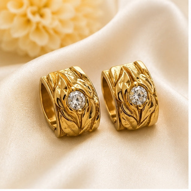Luxury gold-plated stainless steel hoop earrings with crystal centerpiece and engraved leaf design for women by Glanz Jewels.